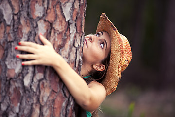 Image showing Young woman embracing a tree