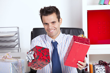 Image showing Happy businessman giving christmas gifts