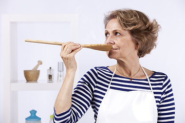 Image showing Senior woman tasting food