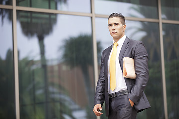 Image showing Businessman walking next to his office