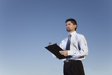 Image showing Powerful businessman holding a notepad