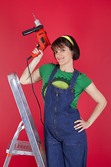 Image showing Stressed woman holding a electric drill