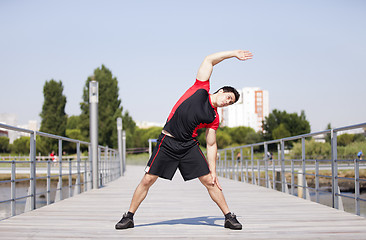 Image showing Athlete warming and stretching