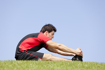 Image showing Athlete warming and stretching