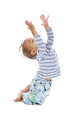 Image showing cute little boy trying to catch something coming from the top, i