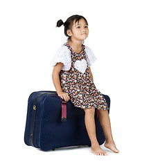 Image showing cute girl sitting on luggage