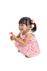 Image showing cute little girl with two lollipops 