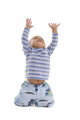 Image showing cute little boy trying to catch something coming from the top, i