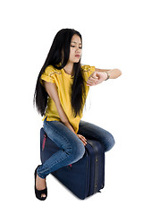 Image showing woman sitting on bag and checking time