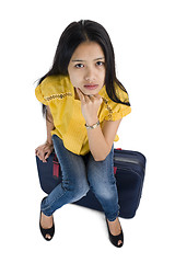 Image showing pretty woman sitting on a bag
