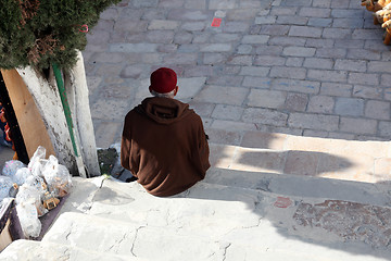 Image showing The old man sitting on the stairs