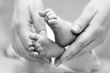 Image showing Mother gentle touch - cute baby feet