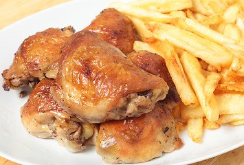 Image showing Roast lemon chicken thighs and fries