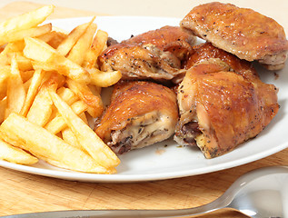 Image showing Roast chicken thighs and fries with spoon