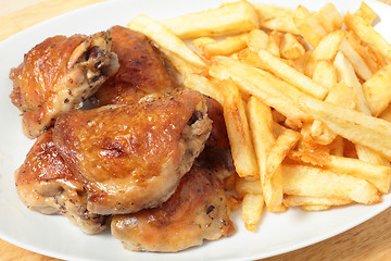 Image showing Roast chicken thighs and fries high angle