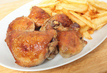 Image showing Roast chicken thighs and fries with spoon