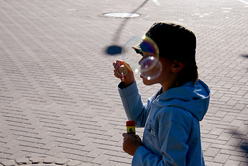 Image showing Kid blowing soap bubbles 