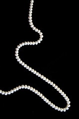 Image showing White pearls on the black silk 