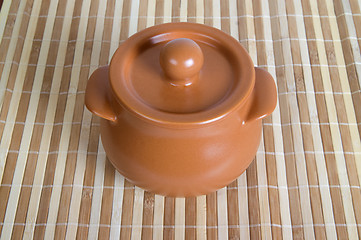 Image showing Ceramic pot on the striped mat