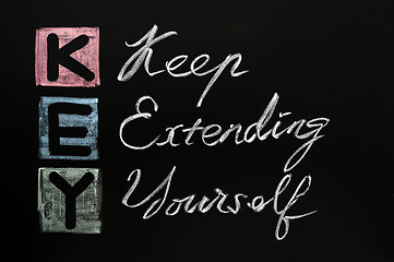 Image showing KEY acronym -Keep extending yourself on a blackboard with words written in chalk. 