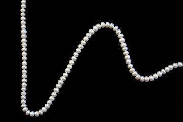 Image showing White pearls on the black silk 