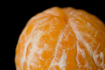 Image showing Close up of a peeled Clementine orange on a black background.