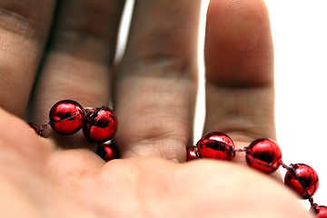 Image showing hand with red pearls