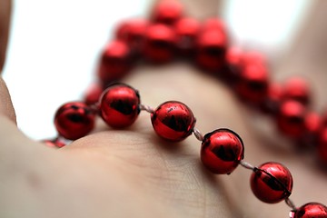 Image showing hand with red pearls