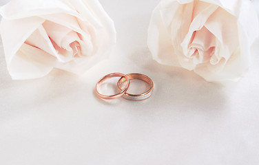 Image showing Wedding rings and roses as background 