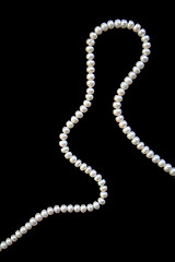 Image showing White pearls on the black silk as background 