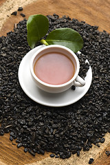 Image showing A cup of green tea with freh leaves