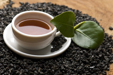 Image showing A cup of green tea with freh leaves