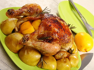 Image showing Chicken stuffed with lemons, apples and rosemary.