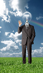 Image showing businessman with lamp-head holding blank card outdoors