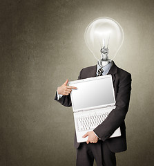 Image showing businessman with lamp-head with open laptop shows something