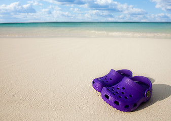 Image showing Small kids boots on the beach sand