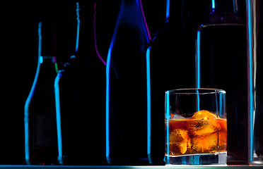 Image showing Row of bottles and drink with ice