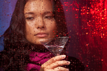 Image showing Sad Asian woman with drink in cold rainy weather