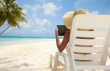 Image showing Woman with tablet computer on the beach