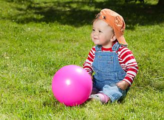 Image showing Toddler sit with ball in the garden