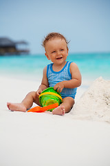 Image showing Kid playing with sand on the beach