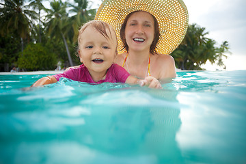 Image showing Kid swimming with mothers help