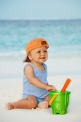 Image showing Kid playing with sand on the beach