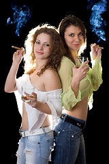 Image showing Two smiling pretty girlfriends with a cigars