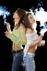 Image showing Two young pretty girlfriends with a cigars