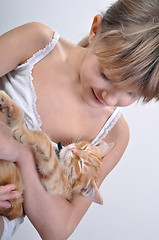 Image showing Adorable girl cradles sleeping kitten