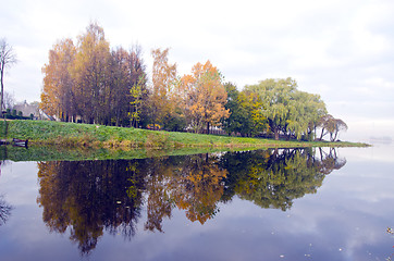 Image showing Beautiful lake and autumn trees reflect on water.