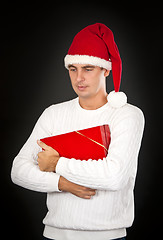 Image showing sad man in a hat Santa with a gift