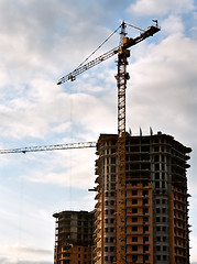 Image showing Stand, house, construction crane in the sky with clouds