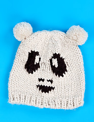 Image showing knitted wool hat with a pattern of little faces